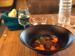 Un mijoté de porc avec ses carotte dans son assiette