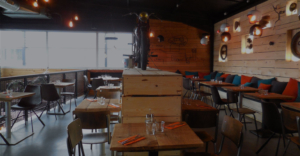 salle du restaurant avec sa déco en bois et pièces de moto
